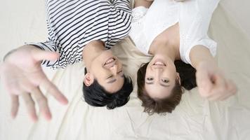superiore Visualizza di giovane asiatico coppia su il letto nel Camera da letto, contento famiglia concetto foto