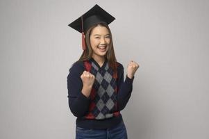 giovane sorridente donna Tenere la laurea cappello, formazione scolastica e Università concetto foto