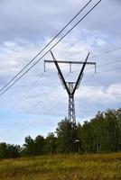 alta tensione energia linea nel il campo su un' estate giorno. un' energia linea nel un' verde campo. foto