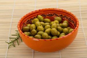 verde olive nel un' ciotola su di legno sfondo foto