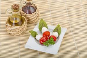 insalata caprese sul piatto e fondo di legno foto