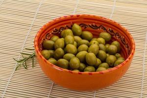 verde olive nel un' ciotola su di legno sfondo foto