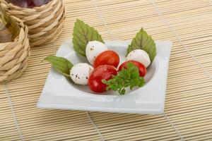 insalata caprese sul piatto e fondo di legno foto