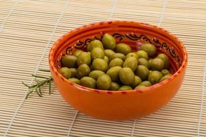 verde olive nel un' ciotola su di legno sfondo foto