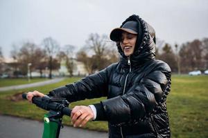 donna nel un' giacca su un elettrico scooter nel un autunno parco. foto