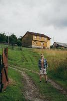 il tipo nel un' camicia e pantaloncini su il lato di il collina foto