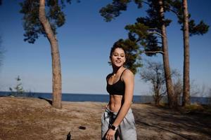 fitness giovane donna passeggiate nel il parco e in posa per il telecamera foto