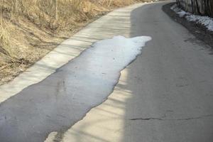 pozzanghera su asfalto. bagnato strada. rovesciato acqua su pedone zona. foto