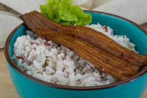 Anguilla con riso nel un' ciotola su di legno sfondo foto