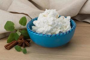 ricotta formaggio nel un' ciotola su di legno sfondo foto