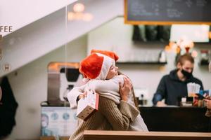 il ragazza dà un' regalo per sua femmina amico nel caffe foto