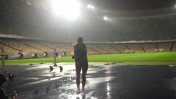 persone partire nel per gli sport a notte stadio nel piovoso tempo metereologico foto