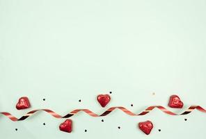 un' festivo piatto posare di dolci nel il modulo di il cuore rosso nastro e coriandoli. copia spazio foto