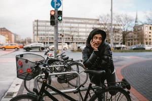 giovane donna in posa nel un' parcheggio lotto con biciclette foto