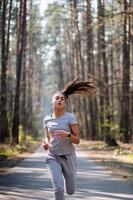 bellissimo giovane donna in esecuzione nel verde parco su soleggiato estate giorno foto