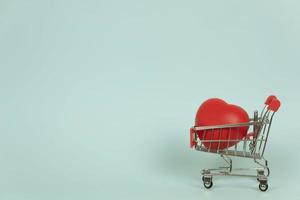 un' shopping carrello con un' rosso cuore nel esso. copia spazio. assistenza sanitaria concetto foto