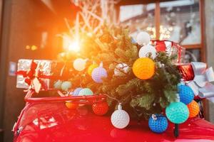 rosso retrò auto con un' Natale albero abete legato per il tetto. foto