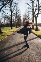ritratto di un' brunetta ragazza avendo divertimento nel un' parco nel il raggi di il luminosa sole. foto