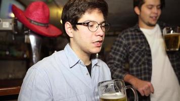 tipo con un' birra nel un' bar con amici su un' Sabato notte foto