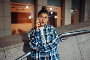 donna parlando su un' smartphone su il notte città foto
