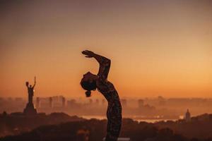 donna fare yoga su il tetto di un' grattacielo nel grande città. foto