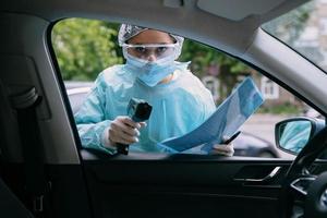 medico donna uso infrarosso termometro pistola per dai un'occhiata corpo temperatura foto