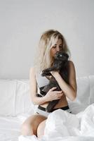 contento giovane donna abbracciare un' gatto foto