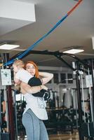 giovane madre con sua giovane figlio nel il Palestra foto