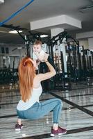 giovane madre con sua giovane figlio nel il Palestra foto