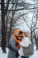 papà mamma e bambino nel il parco nel inverno foto