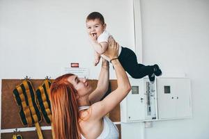 giovane madre con sua giovane figlio nel il Palestra foto