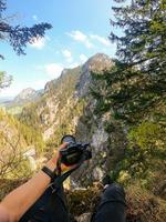 un' fotografo osserva con il suo telecamera nel mano a partire dal il superiore di un' montagna. foto