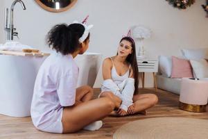 Due ragazze parlando su il bagno pavimento foto