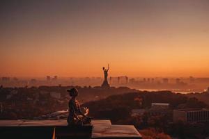 donna fare yoga su il tetto di un' grattacielo nel grande città. foto