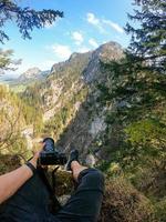 un' fotografo osserva con il suo telecamera nel mano a partire dal il superiore di un' montagna. foto