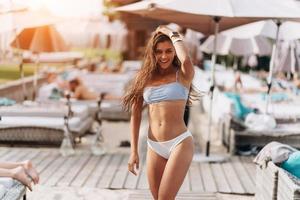 bellissimo giovane donna nel bikini riposo all'aperto di il piscina foto