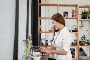 bella giovane donna che è un uomo d'affari asiatico sorridente felice di lavorare con un computer portatile in un bar caffetteria. foto