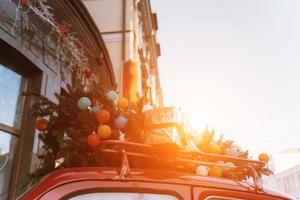 rosso retrò auto con un' Natale albero abete legato per il tetto. foto