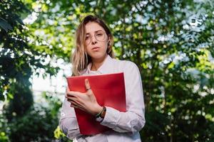 giovane agricolo ingegnere Lavorando nel serra. giovane femmina scienziato guardare a il telecamera foto