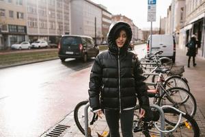 giovane donna scelte su sua bicicletta a partire dal il parcheggio lotto foto