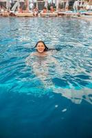 giovane donna nuotatore nel blu piscina acqua foto