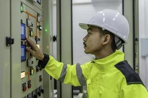 elettrico ingegnere uomo controllo voltaggio a il energia distribuzione Consiglio dei ministri nel il controllo stanza, preventiva Manutenzione annuale, Tailandia elettricista Lavorando a azienda foto