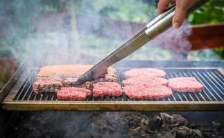 grigliare la carne sulla griglia del barbecue con carbone.