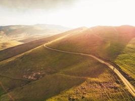 aereo Visualizza ciclista nel panoramico Armenia campagna montagne bicicletta turismo all'aperto assolo nel caldo estate paesaggio con luminosa cielo sfondo su tramonto. ispirazione Ciclismo Immagine foto