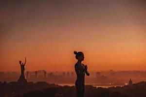 donna fare yoga su il tetto di un' grattacielo nel grande città. foto