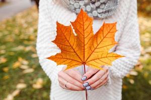 foglie di autunno nelle mani della ragazza foto