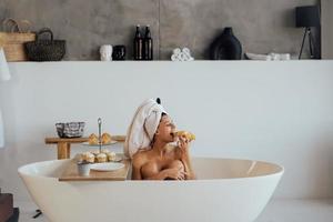 lusso moda donna nel il mattina prendere prima colazione dire bugie nel bagno foto