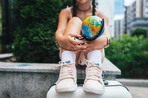 bellissimo giovane donna detiene un' piccolo globo nel sua mani. foto