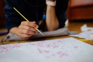 giovane donna disegno posa su il pavimento a casa. foto