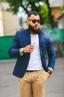 l'uomo con la barba fuma una sigaretta elettronica foto